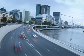 Traffic on Coronation Drive, Brisbane driving along the bank of the Brisbane River with the highrise buildings of the CBD in the background